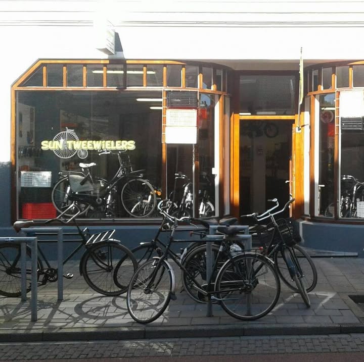 De winkelpui van Sun Tweewielers aan de Van Karnebeekstraat, met fietsen voor de deur